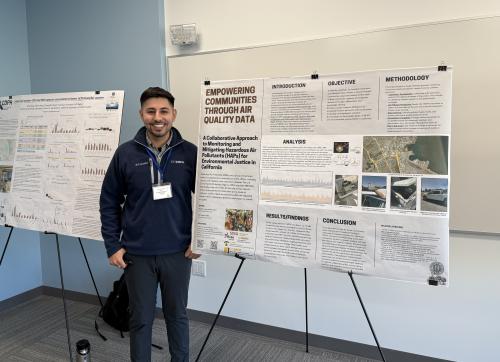 Alex stands beside a poster describing the community research