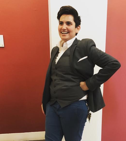 Photo of a white person with short hair posing wearing a suit