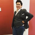Photo of a white person with short hair posing wearing a suit