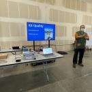 Richard presents on air quality beside laptop and screen